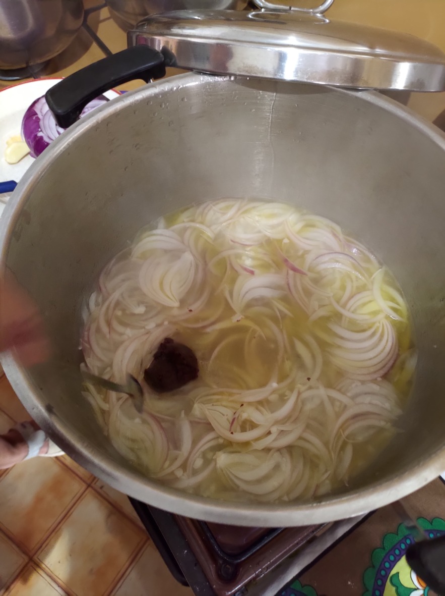 Zwiebeln mit Knoblauch und Tomatenmark werden in etwas Wasser aufgekocht